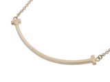 a gold necklace with a curved bar on a chain