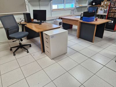 une photo d'une pièce avec un bureau équipé d'un ordinateur et un réfrigérateur