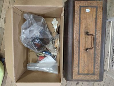 une boîte posée par terre, contenant quelques objets