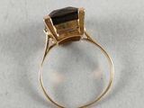 a close up of a gold ring with a black stone on it