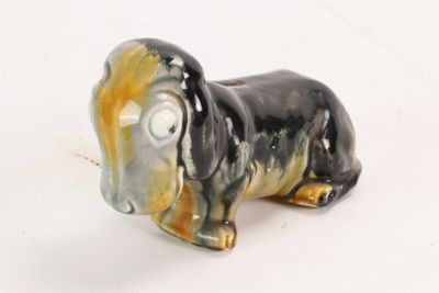 une figurine représentant un teckel assis sur une surface blanche