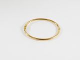 gros plan d'une bague en or sur une surface blanche