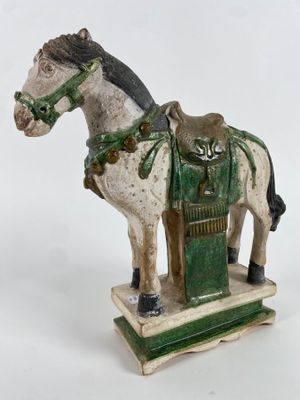 statue d'un cheval avec une selle sur le dos