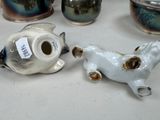 a table with a lot of vases and a dog figurine on it