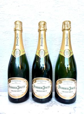 trois bouteilles de champagne posées côte à côte sur une table