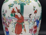 a white vase with a painting on it on a black background