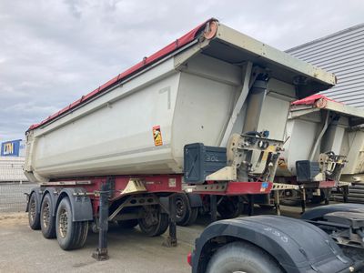 un camion-benne garé à côté d'un immeuble