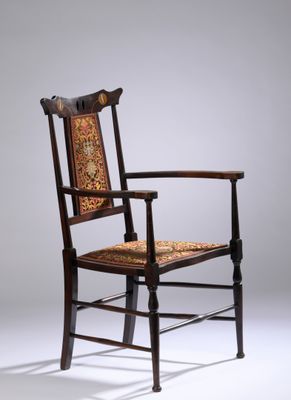 une chaise ancienne en bois avec une assise et des accoudoirs décorés de motifs