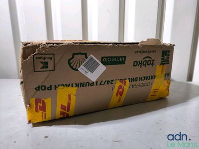 une boîte en carton posée sur une table, sur laquelle est collé un autocollant