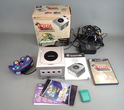 une console Nintendo posée sur une table à côté d'autres objets