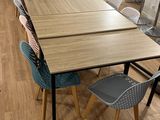 des tables et des chaises dans une pièce avec un parquet et des murs blancs