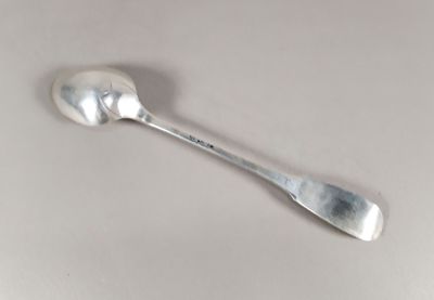 une cuillère et un repose-cuillère sur une surface blanche