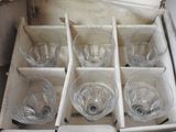 six empty wine glasses in a box on the table