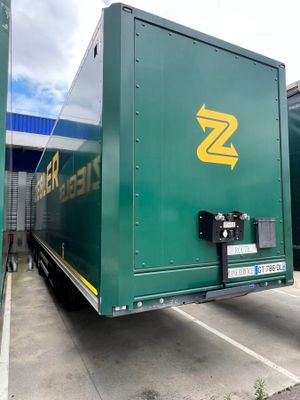 a green box truck that is parked in a parking lot