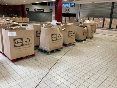 de nombreux cartons posés sur des palettes au milieu de l'entrepôt
