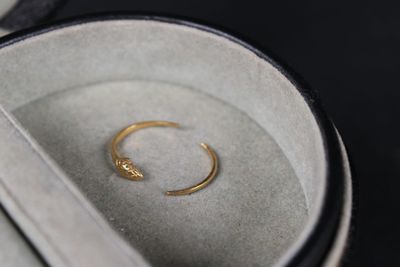 a gold ring sitting in a box with a pair of scissors