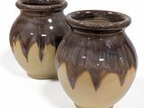 deux vases marron posés côte à côte sur une surface blanche