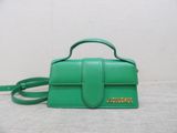 a green handbag with a small strap on a white surface