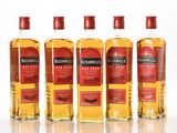 four bottles of bushmill ' s finest bourbons lined up on a white surface