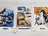 Trois cartes aux motifs différents sont accrochées au mur.
