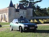 a car parked in front of a castle with a horse in the background