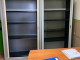 a desk with a book case and a blue folder on it