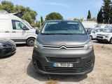 La petite camionnette est garée sur le parking, à côté d'autres voitures.