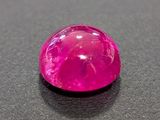 a close up of a pink gemstone on a black surface