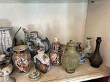 de nombreux vases de toutes sortes posés sur une étagère dans une pièce