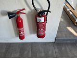 un extincteur et un autre extincteur accroché au mur