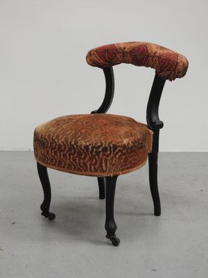 une image représentant une petite chaise dont l'assise est recouverte d'un tissu rouge et orange