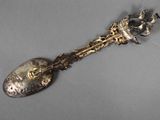 a silver spoon with a flower on it on a table