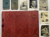 an old red book with pictures of people on it next to other old books