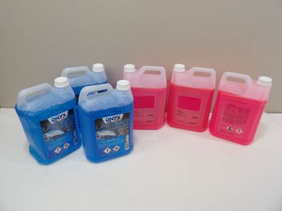 four gallons of liquid sitting next to each other on a table