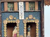 a small wooden house with a thermometer on it