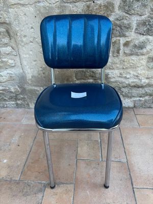 a blue chair that is sitting on a tile floor