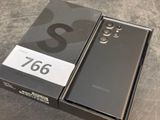 the box is open on the table with the phone in it