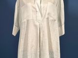 a white shirt on a mannequin stand against a blue wall