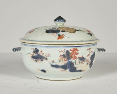 un saladier blanc et bleu avec un couvercle posé sur une table