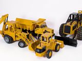 deux camions miniatures et un bulldozer sur fond blanc