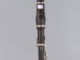 a close up of a clarinet on a clear surface with a gray background