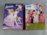 two barbie dolls are sitting side by side on a table