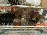 a metal rack filled with bottles and vases in a room
