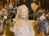 de nombreux vases de fleurs posés sur une étagère devant un tableau