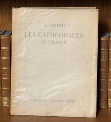 un vieux livre posé sur une étagère en bois, à côté d'une pile de livres