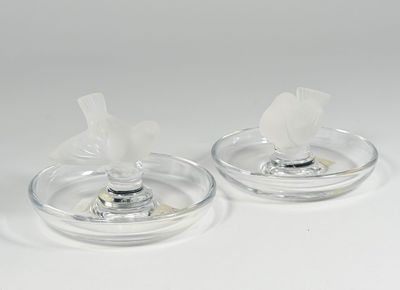 pair of clear glass candle holders with a white flower on each of them