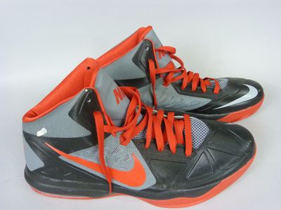 pair of nike basketball shoes with orange laces on a white background