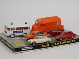 trois petites voitures et un bus exposés sur une table
