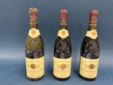 three bottles of wine sitting next to each other on a blue surface