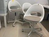 trois chaises blanches dans une pièce où se trouve une imprimante